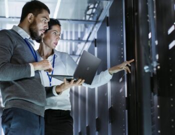 AzureTracks.com - Using Microsoft Teams to coordinate Sentinel incidents - Pictured is a man and woman working together on racks in a datacenter.