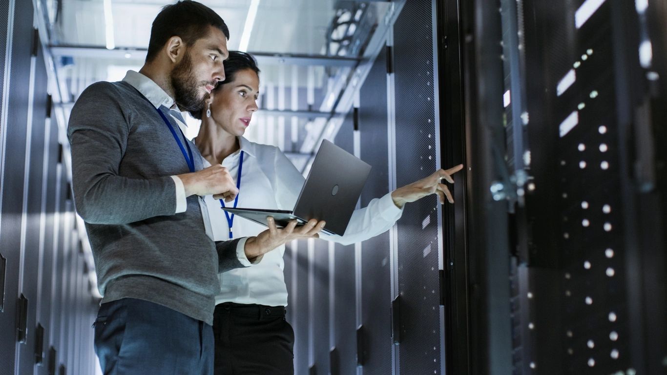 AzureTracks.com - Using Microsoft Teams to coordinate Sentinel incidents - Pictured is a man and woman working together on racks in a datacenter.